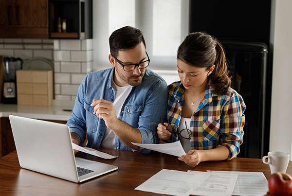 Couple looking at bill on laptop