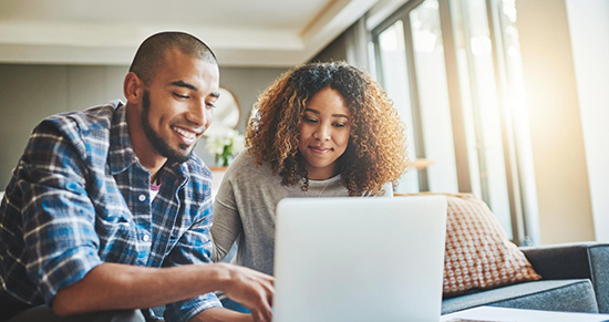 Couple looking at bill on laptop