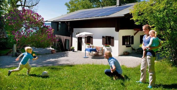 Family playing in Front of House with Solar Panels