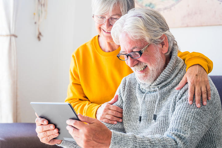 elderly couple looking at ipad
