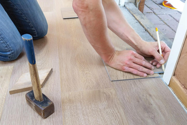 Person measuring on a wood floor