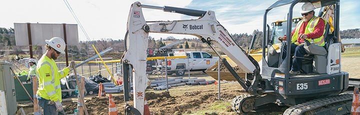 Construction crew using a digger